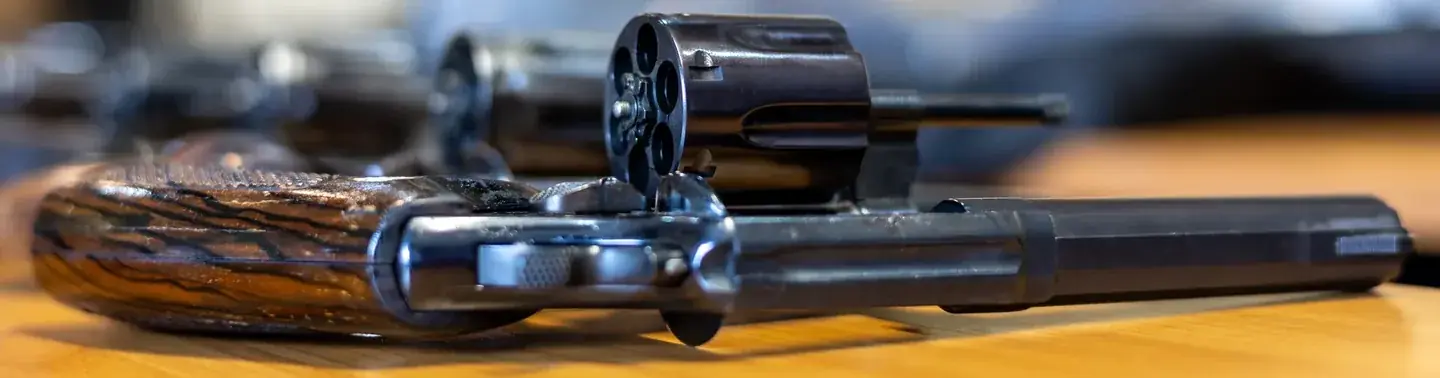 Vintage revolver with wood grips on wooden surface